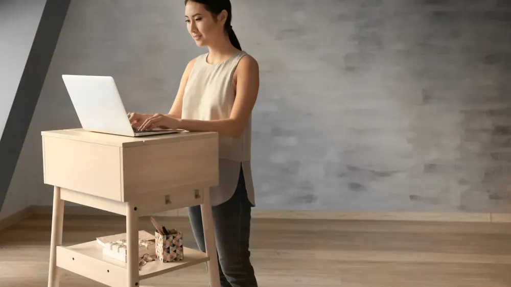 woman typing at standing desk